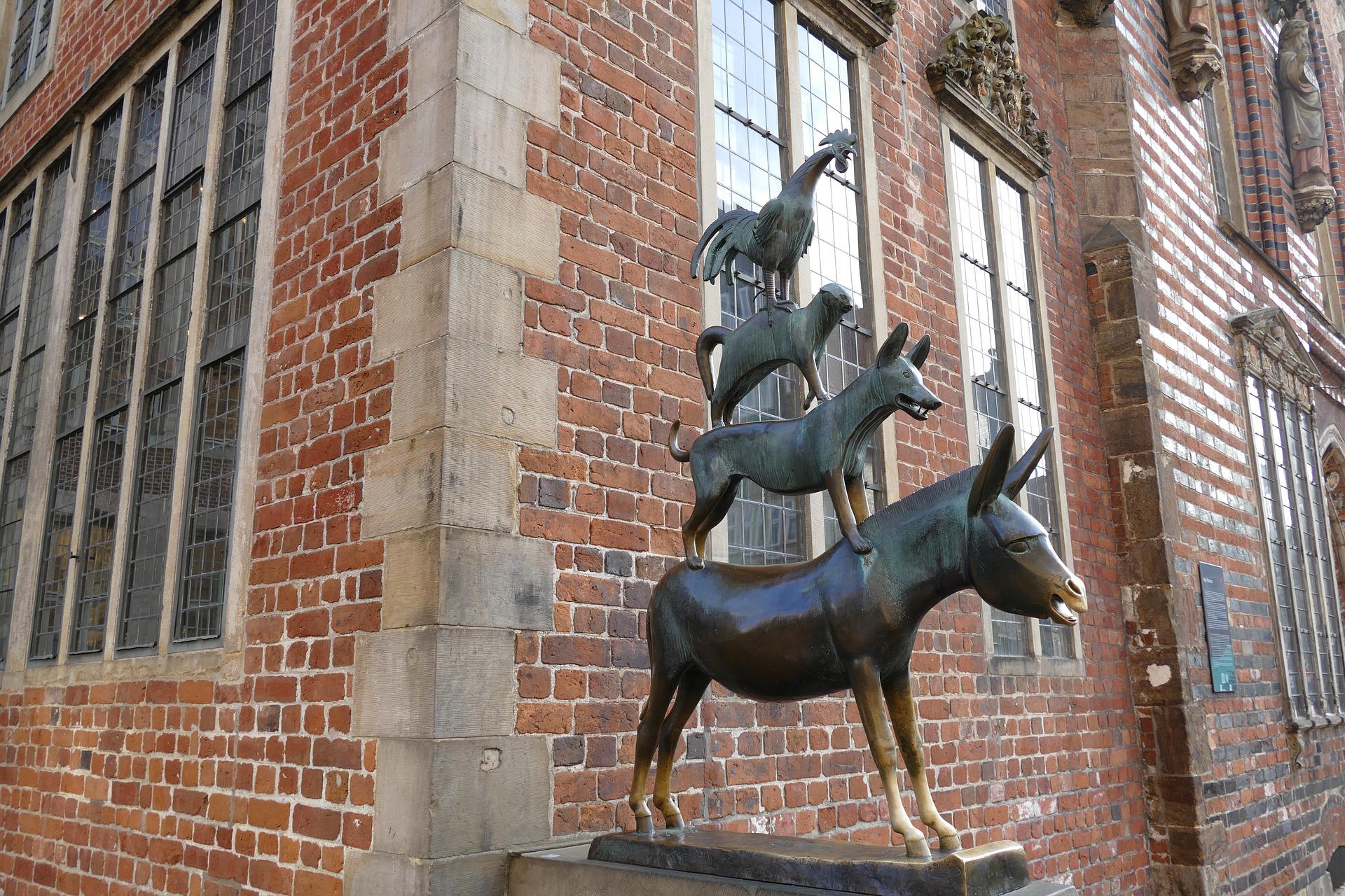 Das Bild zeigt die vier Bremer Stadtmusikanten vor einem historischen Backsteingebaeude in der Altstadt